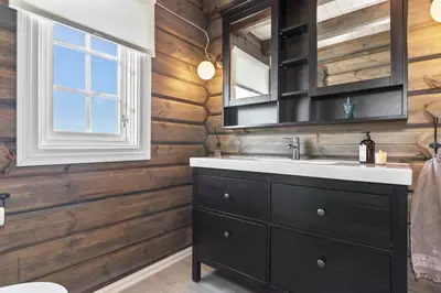 a bathroom with a sink and a wooden wall at New Timber Lodge With Stunning Views And Comfort in Beitostøl