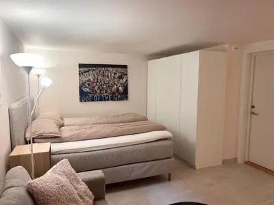 a bedroom with a bed and a painting on the wall at Urban retreat, traditional wooden house in Bergen in Bergen