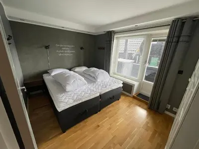 a bedroom with a bed with white sheets and pillows at Geilo Gaarden - Geilo sentrum in Geilo