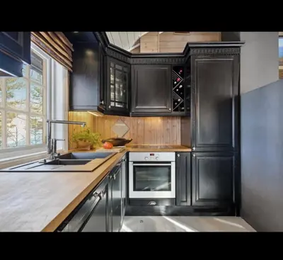 a kitchen with black cabinets and a sink and a stove at Bjorli Mountain Cabin in Bjorli