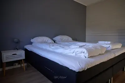 a large bed with white sheets and pillows on it at Rjånes Ferie og Konferansesenter in Ørsta