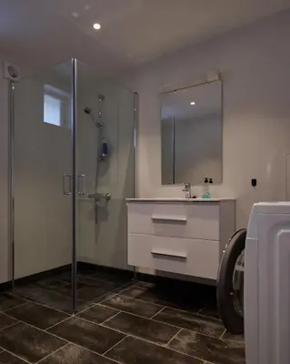 a bathroom with a shower and a sink and a mirror at Rjånes Ferie og Konferansesenter in Ørsta