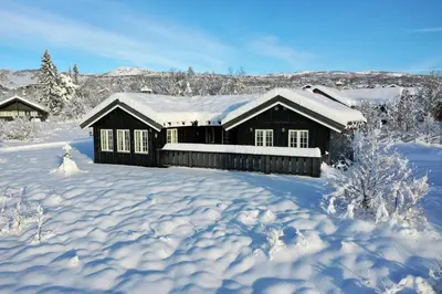 a house covered in snow in a snowy yard at Family-Friendly Cabin With Stunning Outdoor Access in Beitostøl