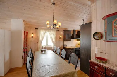 a dining room with a long table and a kitchen at Family-Friendly Cabin With Stunning Outdoor Access in Beitostøl
