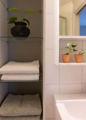 a bathroom with towels and plants on shelves at Unique apartment in midtown in Trondheim