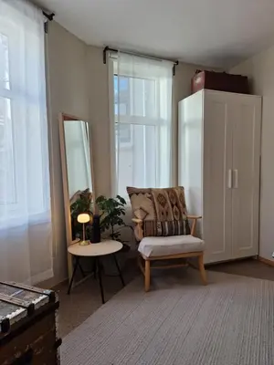 a living room with a chair and a mirror at Unique apartment in midtown in Trondheim