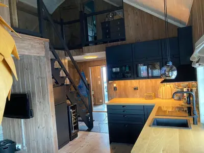 a kitchen with wooden cabinets and a staircase in a house at Cozy Cabin Hovden Fjellpark 71 in Hovden