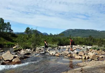 two people standing on rocks in a river at Cozy Cabin Hovden Fjellpark 71 in Hovden