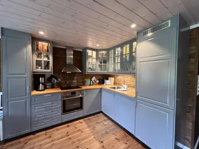 a kitchen with blue cabinets and wooden floors at New Cozy Cabin By Ski Trails And Nature Paths in Beitostøl