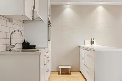 a kitchen with white cabinets and a sink at Bergens Nr1 smau I Enkel innsjekk I Sjøutsikt in Bergen