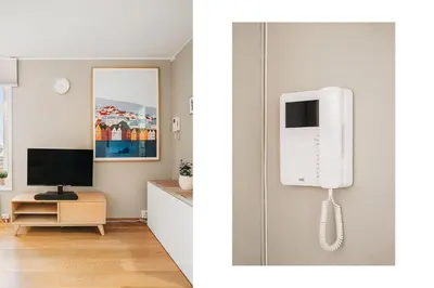 a room with a phone on the wall and a television at Bergens Nr1 smau I Enkel innsjekk I Sjøutsikt in Bergen