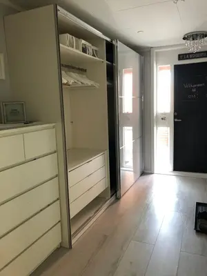 a room with a closet with white drawers and a door at Koselig rekkehus til leie under ski VM i Trondheim in Trondheim