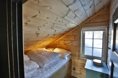 a bed in a wooden room with a window at Relaxing Getaway With Sauna And Terrace in Beitostøl