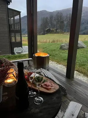 a table with a plate of food and a bottle of wine at Stylish apartment in Myrkdalen in Vossestrand