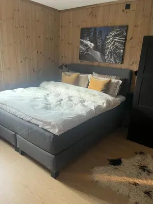 a large bed in a bedroom with a rug at Stylish apartment in Myrkdalen in Vossestrand