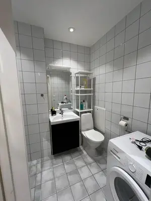 a white bathroom with a toilet and a sink at Apartment near City Center in Trondheim