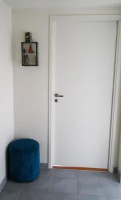 a white door with a blue stool in a room at Solrik leilighet på Byåsen in Trondheim