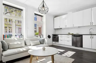 a white living room with a couch and a table at Modern apartment close to the city center in Trondheim