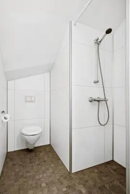 a white bathroom with a toilet and a shower at Modern apartment close to the city center in Trondheim