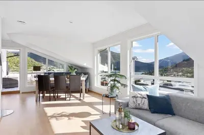a living room with a couch and a table at 4 roms leilighet ved Fosshaugane Campus in Sogndal