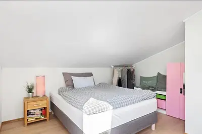 a bedroom with a large bed and a pink cabinet at 4 roms leilighet ved Fosshaugane Campus in Sogndal