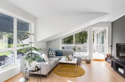 a living room with a couch and a table at 4 roms leilighet ved Fosshaugane Campus in Sogndal