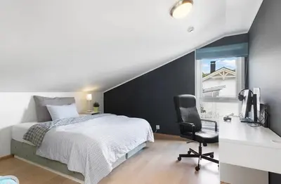 a bedroom with a bed and a desk and a chair at 4 roms leilighet ved Fosshaugane Campus in Sogndal