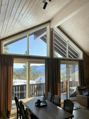 a dining room with a table and a large window at Modern Cabin At The Gateway To Jotunheimen in Randsverk