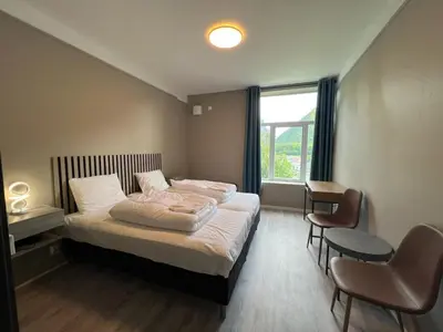 a bedroom with a bed and a desk and a window at Åndalsnes house in Åndalsnes