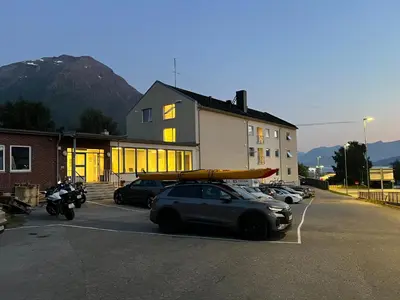 a car parked in a parking lot with a kayak on its roof at Åndalsnes house in Åndalsnes