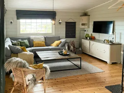 a living room with a couch and a table at Family Cabin With Sun And Views At Ljøsheim in Mesnali