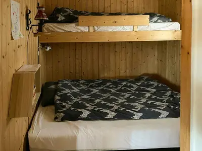 two bunk beds in a wooden room with a bedsheet at Family Cabin With Sun And Views At Ljøsheim in Mesnali