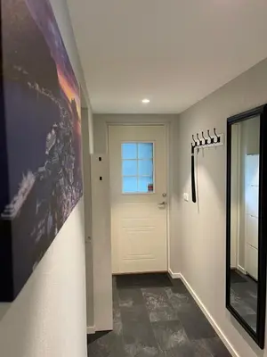 a hallway with a white door and a window at Rancho Apartment in Langevåg in Sula