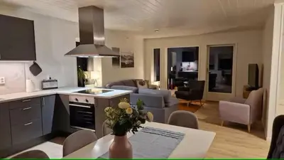 a kitchen and living room with a table and a kitchen and a living room at Lom in Lom