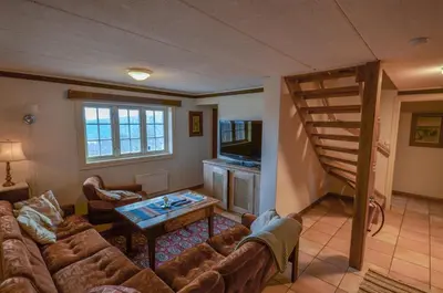 a living room with a couch and a spiral staircase at Large Cabin With Stunning Views! in Beitostøl