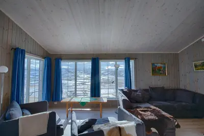 a living room with blue curtains and a couch at Modern Cabin At The Foot Of Bitihorn in Beitostøl