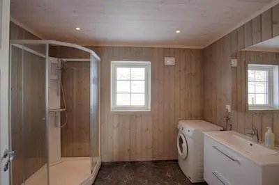 a bathroom with a shower sink and a washing machine at Modern Cabin At The Foot Of Bitihorn in Beitostøl
