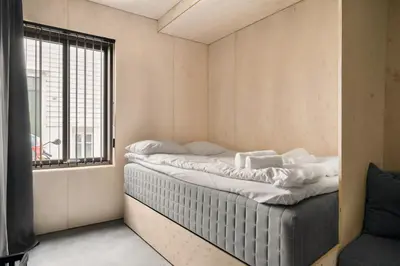 a bed in a room with a window at Comfy studio apartment 200m from bryggen in Bergen