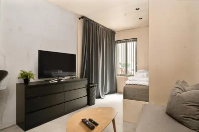 a living room with a television and a couch at Comfy studio apartment 200m from bryggen in Bergen