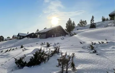 a snow covered hill with a house in the background at Gorgeous Home In Kvam With Sauna in Kvam
