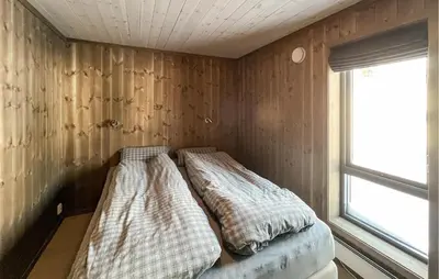 two beds sitting in a room with a window at Gorgeous Home In Kvam With Sauna in Kvam