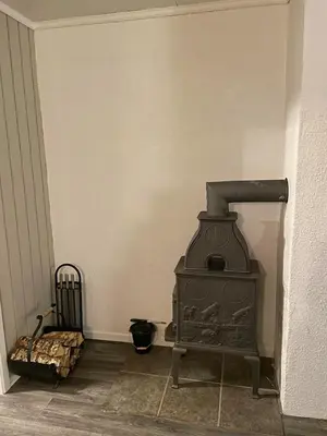 an old stove in a corner of a room at Leilighet i Sør-Fron kommune in Sør-Fron