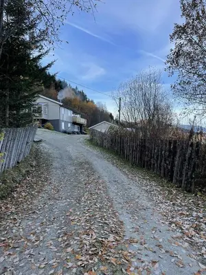 a dirt road with a fence and a house at Leilighet i Sør-Fron kommune in Sør-Fron