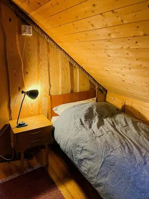 a bedroom with a bed and a lamp on a night stand at Seaside Cabin With Archipelago Views In Radøy in Bøvågen