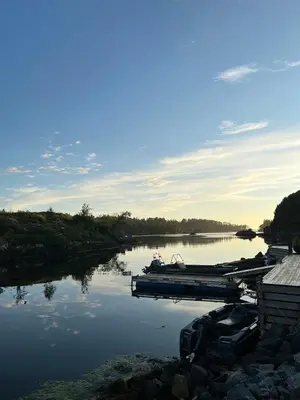 a couple of boats are docked on a river at Seaside Cabin With Archipelago Views In Radøy in Bøvågen