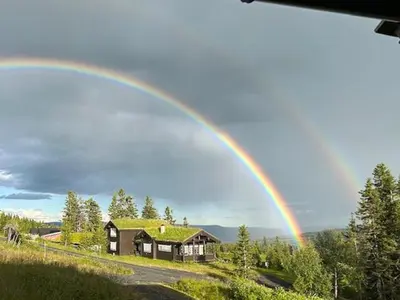 a rainbow in the sky over a house at Mountain Cabin With Views At Skeikampen in Svingvoll