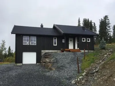 a black house with a white garage at Mountain Cabin With Views At Skeikampen in Svingvoll