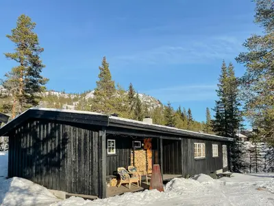 a small black cabin in the snow with trees at Modernized Cabin At Norefjell With View in Eggedal