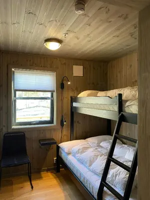 a bedroom with two bunk beds and a chair at Modern Apartment With Views Of Trysil Mountain in Trysil