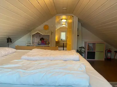a large white bed in a room with a ceiling at Child-friendly holiday home in Ålesund